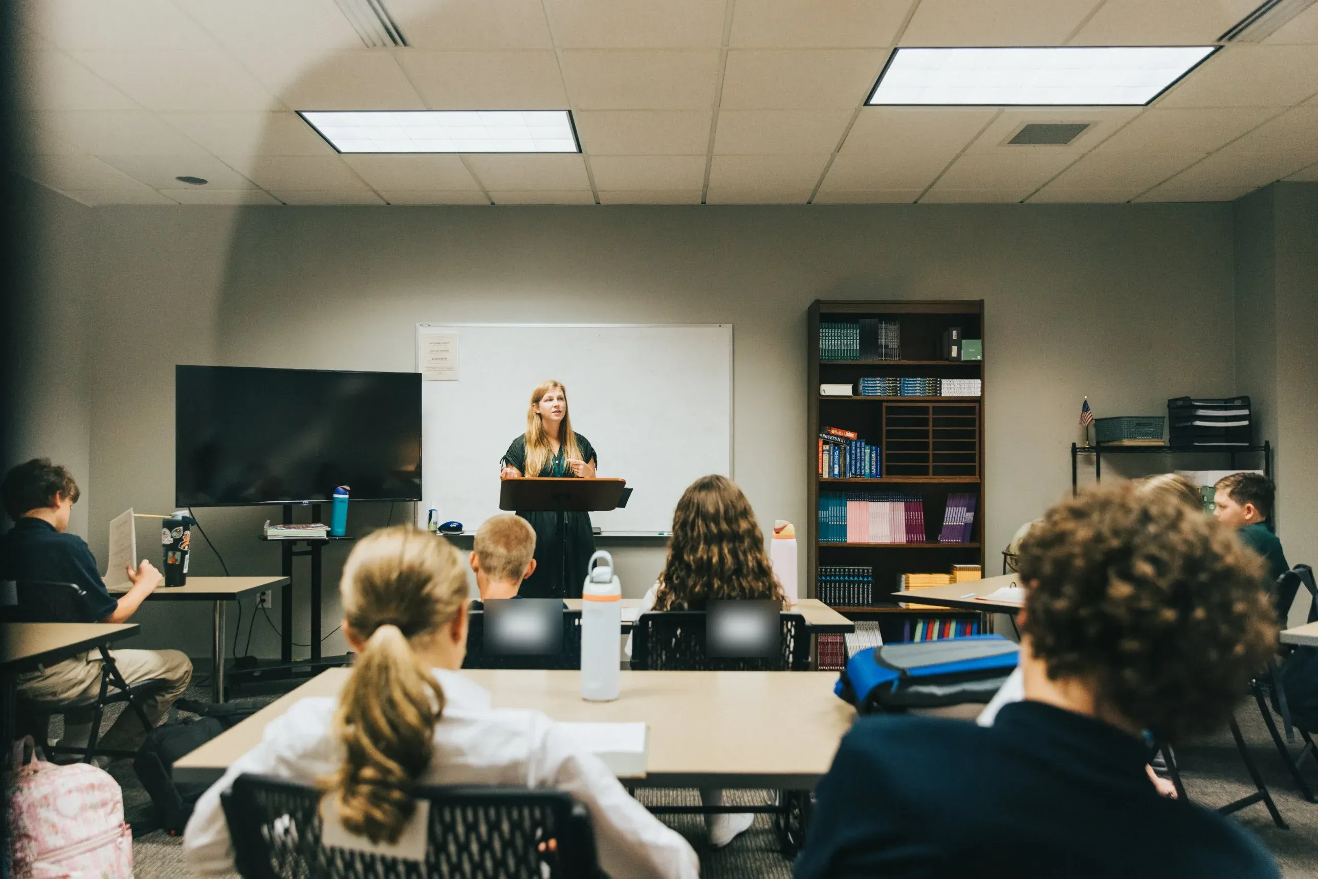 Upper-school students listening to their teacher at the lectern